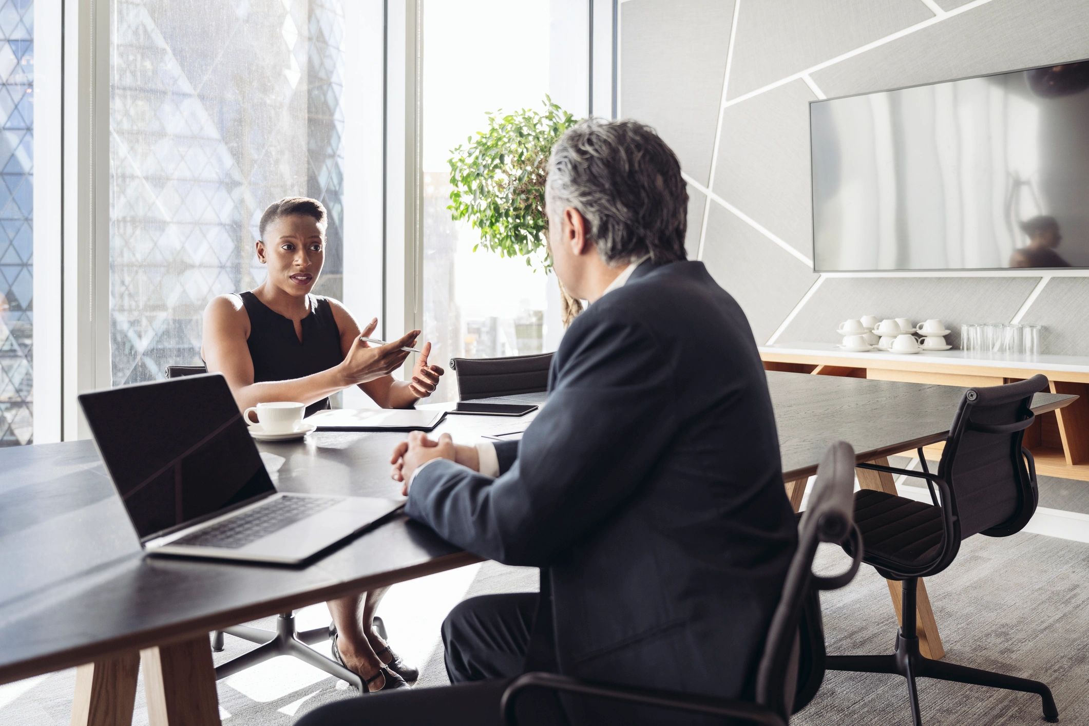Two business professionals in conversation across a conference table