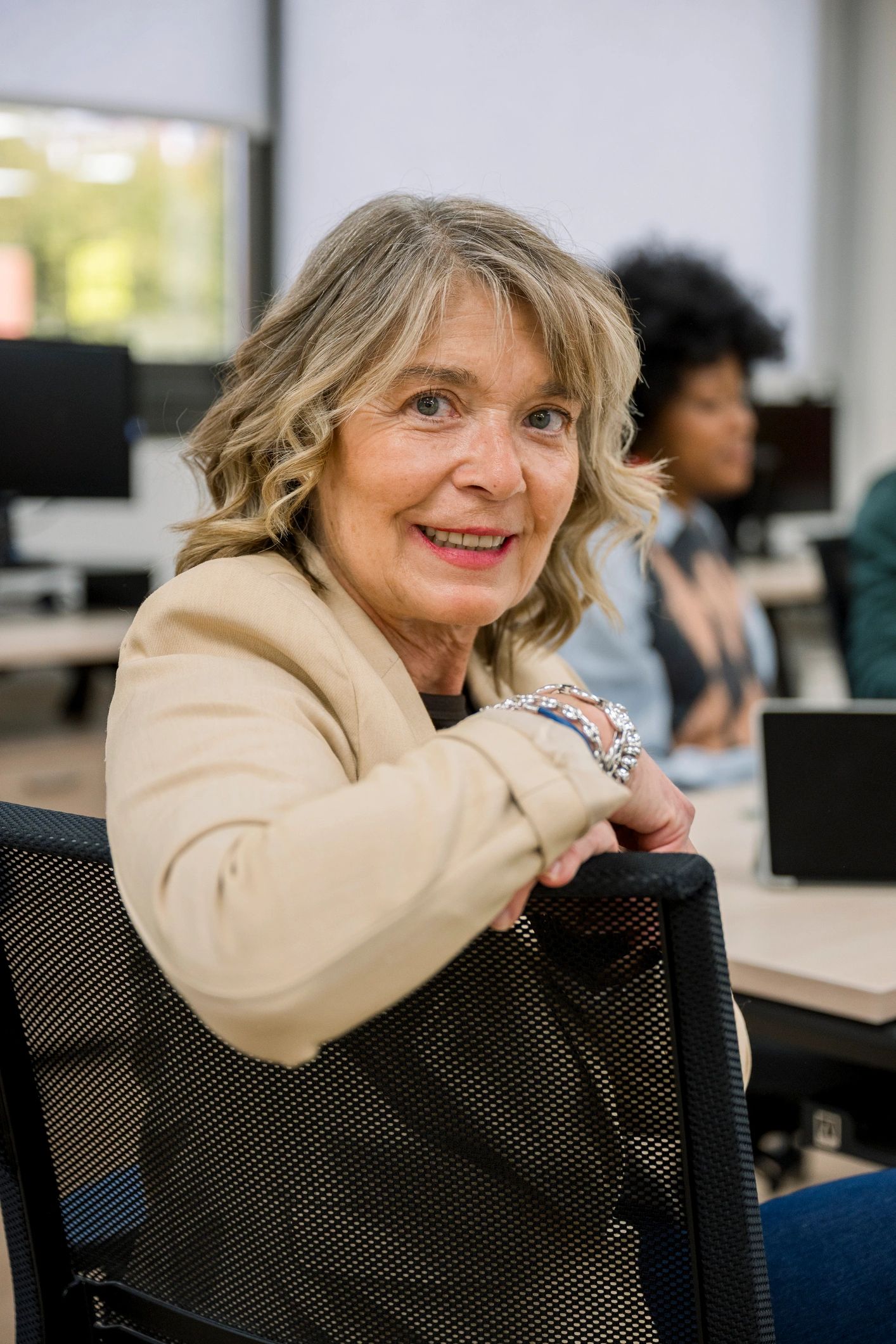 Mature mentor smiling in a workshop setting